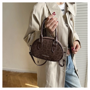 Close-up of leopard print mini handbag with Creative Cat logo and detachable strap