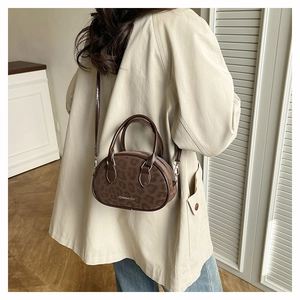 Chic leopard print oval handbag styled with a minimalist beige coat and casual jeans