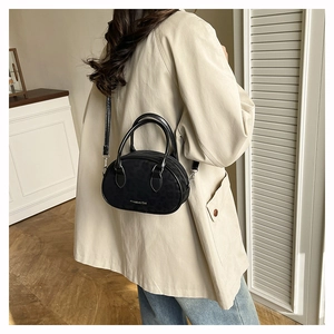 Lifestyle view of a black leopard print mini bag with Creative Cat logo on a trench coat