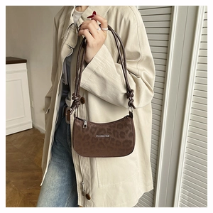 Close-up of leopard print hobo bag with Creative Cat text and knotted shoulder strap
