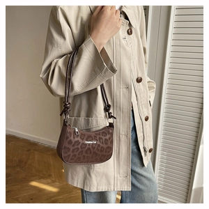 Detail of leopard print shoulder bag with knotted leather strap and Creative Cat text