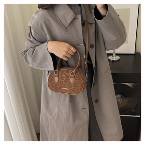 Brown leopard print Boston bag shown being carried as a shoulder bag in lifestyle setting