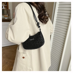Chic black leopard embossed shoulder bag with Creative Cat text shown on a model