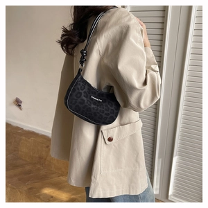 Close-up of Creative Cat black leopard print shoulder bag on model in trench coat