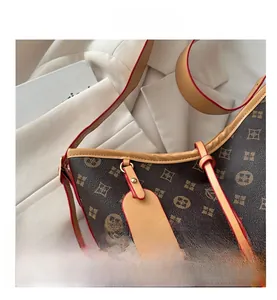 Dettaglio della borsa tote marrone vintage con cinturini in pelle e targhetta logo