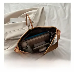 Vista dettagliata dell'interno di una capiente borsa shopper con libro, ombrello e oggetti