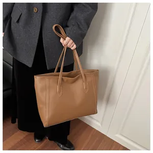 Braune strukturierte Tragetasche kombiniert mit grauem Wollsakko für den Business-Look