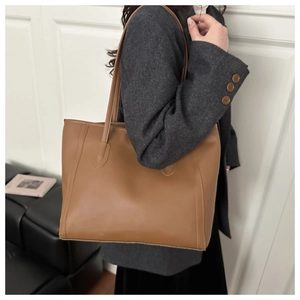 Vue détaillée du sac cabas marron avec coutures verticales et longues anses d'épaule
