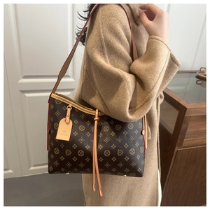 Dettaglio della borsa tote vintage con manici in pelle e rifiniture rosse sui bordi