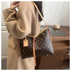 Dettaglio del cinturino in pelle e del cartellino sulla borsa tote vintage con monogramma