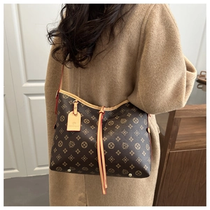 Dettaglio della borsa shopper monogram con finiture in pelle e borchie dorate