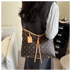 Borsa tote classica con monogramma e chiusura a coulisse indossata da una modella
