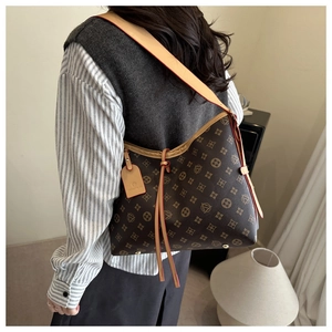 Dettaglio della borsa hobo monogramma marrone scuro con ampia tracolla in pelle