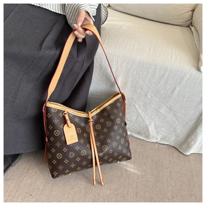Dettaglio della borsa hobo vintage marrone con monogramma e tracolla in pelle