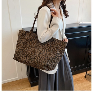 Close-up of leopard print tote bag texture and reinforced handles for shoulder carry