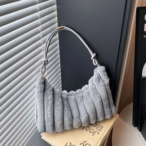 Gray plush shoulder bag with vertical pleated texture and leather strap on vintage books