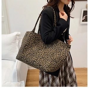 Detail of large leopard print tote bag in canvas fabric with matching shoulder straps