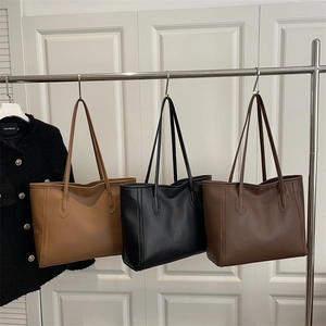 Three minimalist large capacity PU leather tote bags in light brown, black, and dark brown