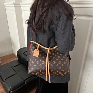 Borsa tote vintage marrone con monogramma da donna indossata dalla modella elegante