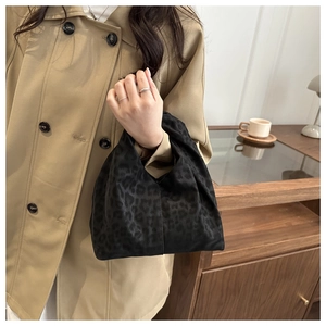 Detail of leopard print satin handbag styled with a classic trench coat for women