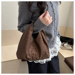 Chic brown leopard print suede handbag shown in a cozy indoor lifestyle setting