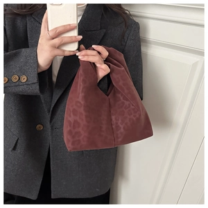 Close-up of a burgundy leopard print cloud bag with soft pleated fabric and chic design