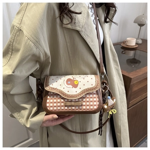 Close-up of women's cartoon embroidery bag featuring vintage plaid and polka dot pattern