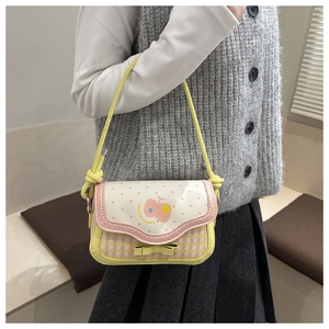 Detail of cartoon embroidery on mini handbag with yellow bow and polka dot patterns