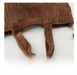 Detail van bruine corduroy draagtas met versterkte stiksels en gestreepte stoftextuur