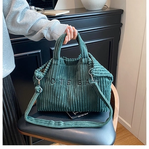 Detail van de donkergroene corduroy draagtas met TOTE BAG borduursel en een schouderriem