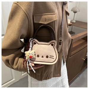 Détail du sac selle chat mignon avec broderie et poignée ronde marron