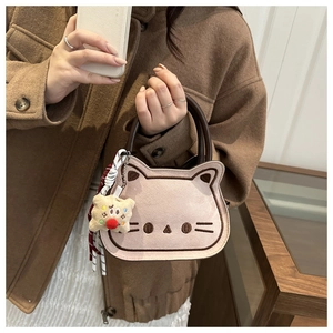 Detail of the pink suede cat bag featuring brown embroidery and a plush star charm