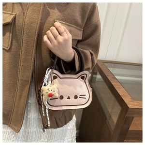 Vue détaillée du sac selle chat rose avec broderie et accessoire de charme en peluche