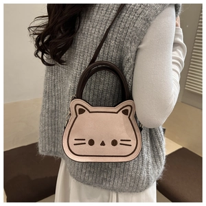 Detail of pink cat-shaped saddle bag showing cute facial embroidery and shoulder strap