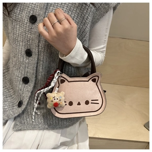 Détail du sac selle chat rose avec broderies et breloques tissées colorées