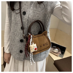 Close-up of brown cat-shaped saddle bag with cute ear details and plush charm