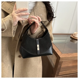 Dettaglio di una borsa leopardata chic con chiusura a scatto dorata e finitura in pelle scamosciata
