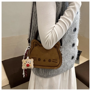 Détail du sac selle chat marron avec broderie et accessoire de charme en peluche doux