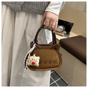 Détail du mini sac selle chat marron avec breloque peluche et foulard en soie rayé