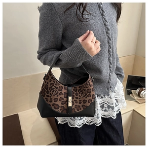 Dettaglio borsa con stampa leopardata e floreale, chiusura dorata e rifiniture in pelle