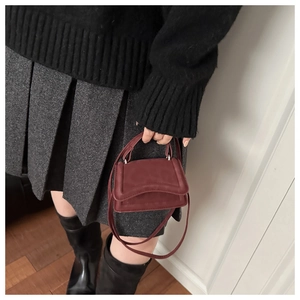 Dettaglio mini borsa in pelle scamosciata bordeaux con chiusura in metallo argento