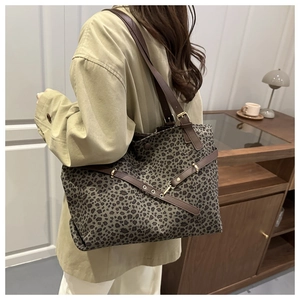 Détail du grand sac cabas en toile léopard avec bandoulière en cuir et boucles métalliques