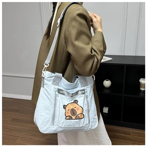 Close-up of light blue capybara pattern canvas crossbody bag with adjustable shoulder strap