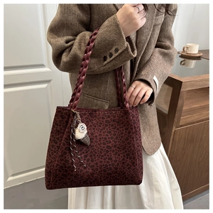 Dettaglio borsa tote leopardata con manici intrecciati e ciondolo a forma di gelato morbido