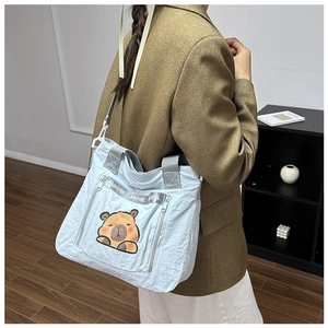Close-up of light blue nylon tote bag featuring cute capybara print and MKPBL ribbon