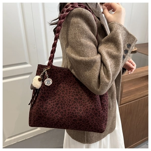 Dettaglio borsa tote leopardata bordeaux con tracolla intrecciata e ciondolo a pecora