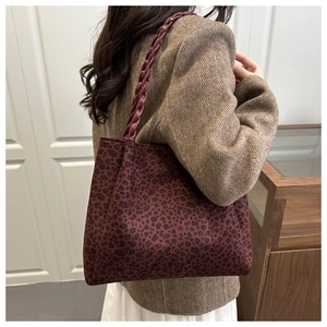 Dettaglio della borsa tote vintage leopardata con manici in pelle intrecciata rosso scuro