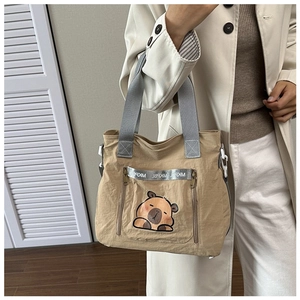 Detail showing cartoon capybara print and MKPBL ribbon on khaki canvas tote bag