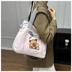 Detailed view of pink tote bag with cute capybara print and wide textile shoulder strap