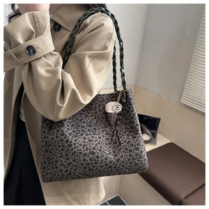 Dettaglio borsa leopardata con manici intrecciati verdi e ciondolo a forma di gelato